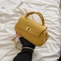 Bright yellow PU leather crossbody bag with knot handle and golden chain strap on white linen - Yellow