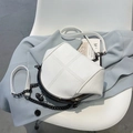White faux leather crossbody shell bag with cross stitching on a blue blazer - White