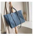 Blaue Stoff-Tragetasche mit Ledergriffen und Metallkette an einem Holzkleiderbügel - Blau