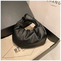 Modern black pleated leather handbag with knot handle design on a luxury gift box - Black