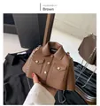Détail macro du sac bandoulière marron en forme de veste avec chaîne argentée - Marron