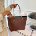 Borsa tote marrone scuro con trama a coccodrillo e catena dorata su una modella elegante - Marrone