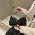 Detail of a black leather underarm bag with gold horseshoe buckle on a cream blazer - Black (3)