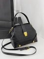 Detalle de bolso negro textura cocodrilo con herrajes dorados y cierre de doctor - Negro
