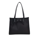 Dettaglio della borsa tote nera con goffratura a righe verticali e grande fiocco in pelle - Nero