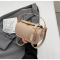 Detail einer strukturierten beigefarbenen Koffer-Handtasche mit goldenem Muschelverschluss - Khaki