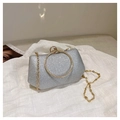 Macro view of silver sequin clutch bag with sparkling texture and golden ring handle - Silver