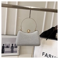 Detail of silver sequin evening bag with gold metal handle and pearl clasp closure - Silver