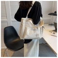 Versátil bolso tote de lona blanca con bolsillos laterales y etiqueta circular decorativa - Blanco Roto