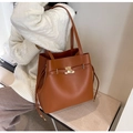 Braune Shopper-Tasche mit goldenem Drehverschluss und Tunnelzug von Model getragen - Braun