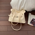 Borsa tote beige plissettata minimalista con fibbia argentata su pavimento in legno - Bianco