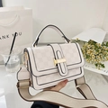 Detail of checkered shoulder bag with gold clasp and wide canvas strap in chic setting - White
