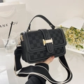 Close-up of black leather crossbody bag featuring checkered embossing and white stitching - Black