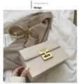 Dettaglio borsa beige in pelle con fibbia geometrica dorata e tracolla a catena - Beige