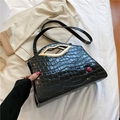 Black crocodile embossed handbag with unique gold lip handle and red accent - Black