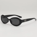 Schwarze ovale Sonnenbrille mit grauen Gläsern und silbernem Herz-Detail am Bügel - Schwarzer Rahmen Graue Gläser