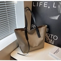 Large khaki tote bag with black handles on a white table in a bright minimalist setting - Khaki