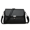 Fashionable black pebbled leather crossbody bag with silver leaf pendant on white background - Black