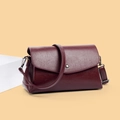 Detalle de bolso bandolera burdeos de cuero con botón de presión metálico y textura granulada - Rojo