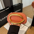 Orange woven handbag with bold gold C-shaped metal handle and slim chain strap - Orange