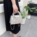 Sac bandoulière argenté motif serpent avec poignée ronde et chaîne dorée sur mannequin - Doré