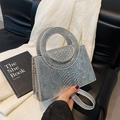 Sac à main argenté effet serpent avec poignée ronde et chaîne dorée sur canapé noir - Argenté