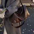 Deep brown oversized PU leather tote bag styled with a grey blazer in a fall setting - Dark Brown
