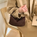Bolso retro de ante marrón con detalles dorados combinado con un abrigo beige - Marrón