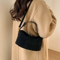 Bolso media luna de cuero negro mate con herrajes dorados sobre abrigo de lana beige - Negro