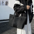 Bolso tote negro minimalista con costuras en contraste y detalles de cuero trenzado - Negro