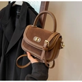 Dettaglio della borsa a tracolla marrone vintage con chiusura dorata e design patchwork - Marrone