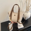 Bolso trapecio tejido beige con correas de cuero marrón y detalles metálicos dorados - Blanco