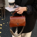 Brown vintage faux leather handbag with woven wide shoulder strap and metal buckle closure - Brown