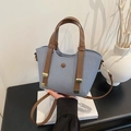Light blue textured bucket bag with brown leather handles and adjustable shoulder strap - Blue
