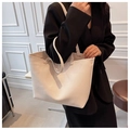 Detail of minimalist beige lychee grain leather tote bag showing large capacity structure - Beige