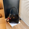 Sac seau classique en cuir noir avec fermoir doré et charmant pendentif cerise - Style avec pendentif cerise / Noir