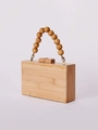Detailed macro view of natural bamboo woven handbag with wooden beaded handle and gold metal rings - Natural Bamboo Color