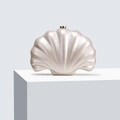 Close-up of shell-shaped evening clutch with pearlescent finish and gold metal clasp - Shell Color