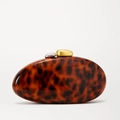 Detail view of tortoiseshell evening clutch with dual-tone gold and silver pebble clasps - Acrylic Tortoise Shell