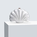 Detailed view of the pearlescent shell-shaped acrylic clutch with gold clasp for weddings - White