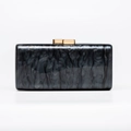 Detailed macro shot of rectangular acrylic evening clutch with gray marble texture and gold clasp - Black