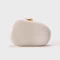 Close-up of beige pebble clutch bag featuring a sleek bean-shaped golden metal clasp - White