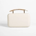 Detailed view of cream PU evening clutch with golden metal handle and pleated texture - White