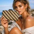 Schicke geflochtene Abendtasche mit Goldschnalle am Model für einen sommerlichen Look - Schwarz