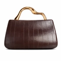 Detail of dark brown textured leather bag with wavy gold metal handle in minimalist style - Brown
