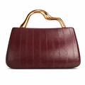Elegant wine red PU leather handbag with luxury gold geometric handle on white background - Burgundy