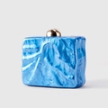 Close-up of blue marble acrylic evening clutch with a gold spherical metal clasp - Sky Blue