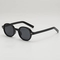 Lunettes de soleil ovales rétro noires avec détails argentés, vue de profil à 45° - Monture Noire Verres Gris