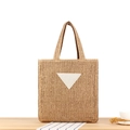 Woven straw tote bag in natural wood tone with white triangular patch detail - Camel