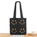 Black hand-woven tote bag featuring colorful beaded smiley faces and long handles - Black